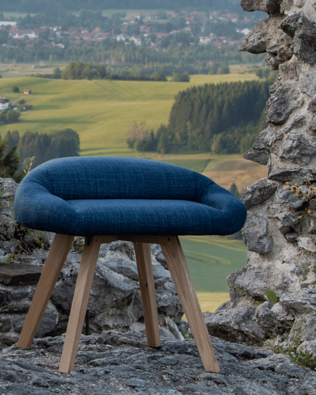 Bürostuhl für den Schneidersitz in Blau und Buche, abgebildet draussen auf Burgruine