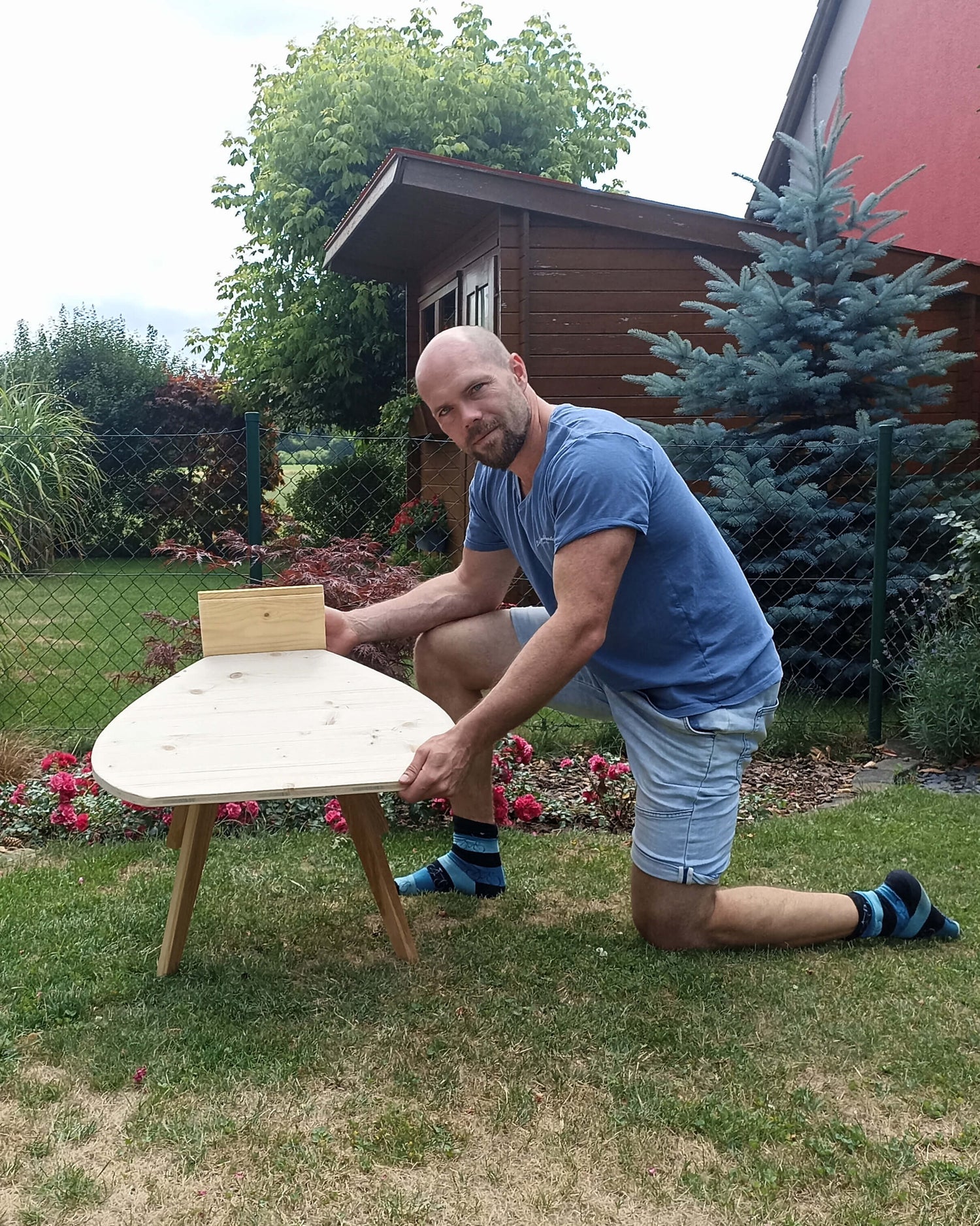Lukas Richter zeigt Prototyp des Stuhls für den Schneidersitz, im Garten